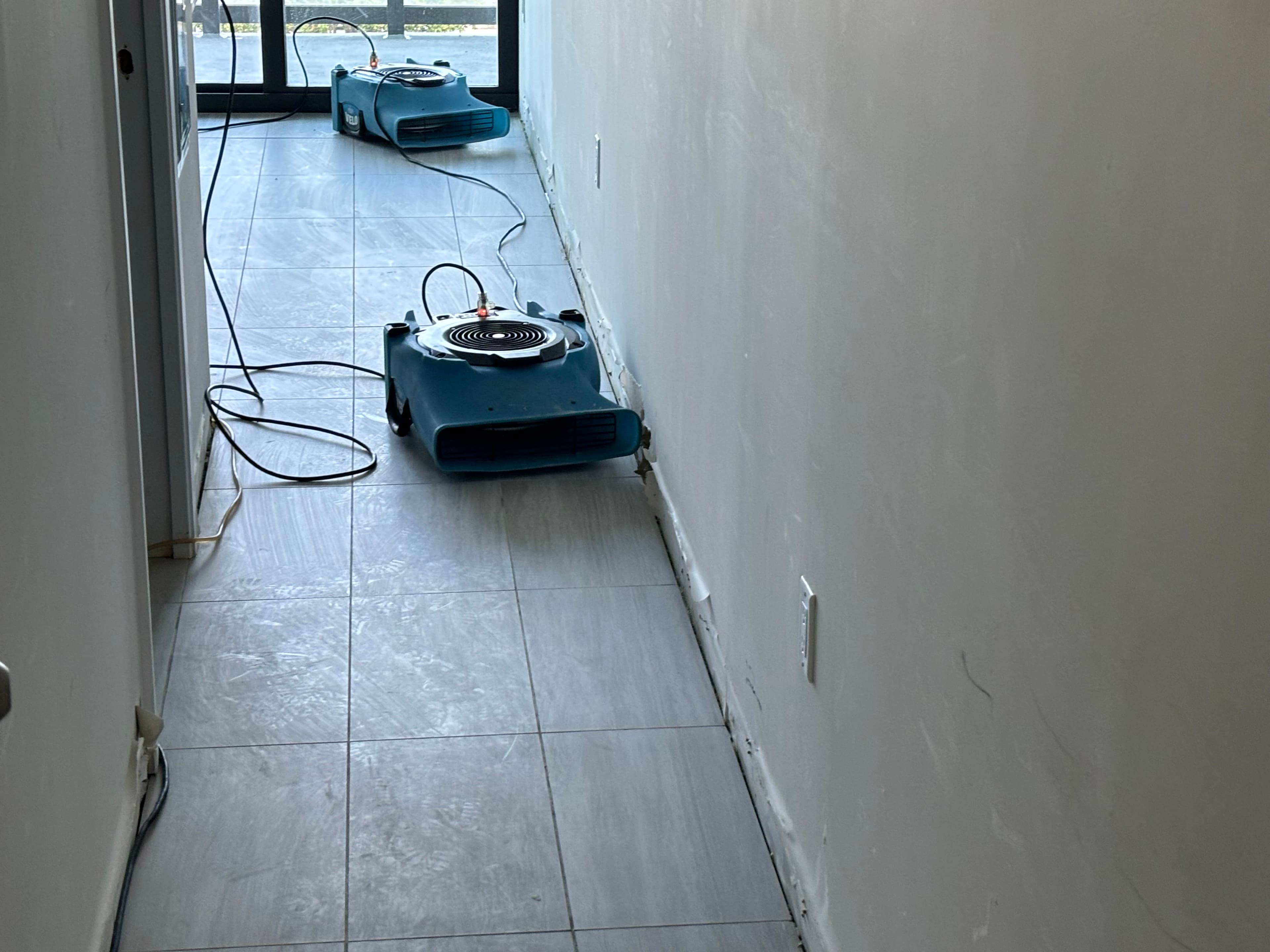 Industrial air movers deployed in water-damaged South Florida hallway