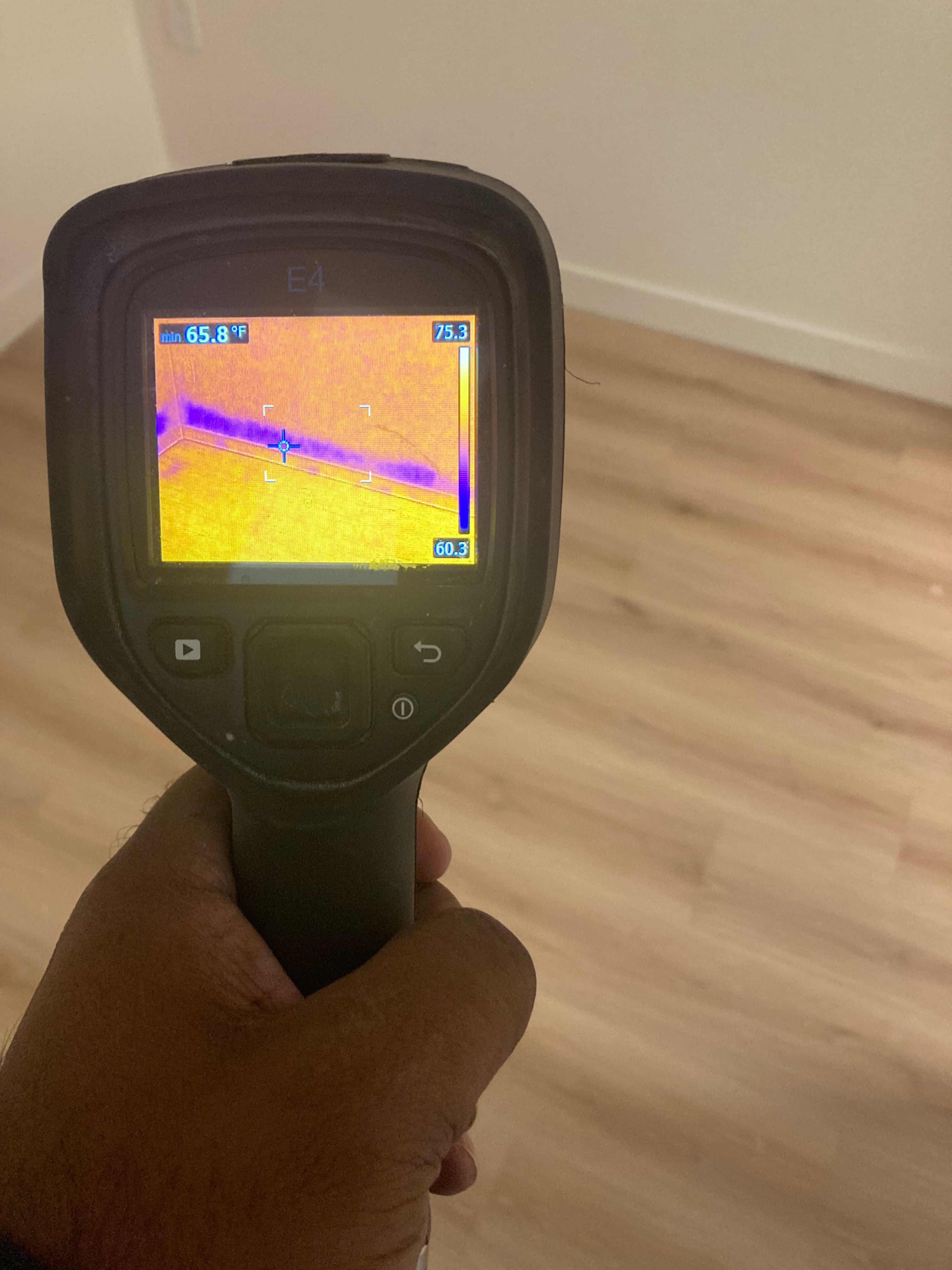 Thermal imaging camera detecting hidden moisture behind a wall in a NYC building